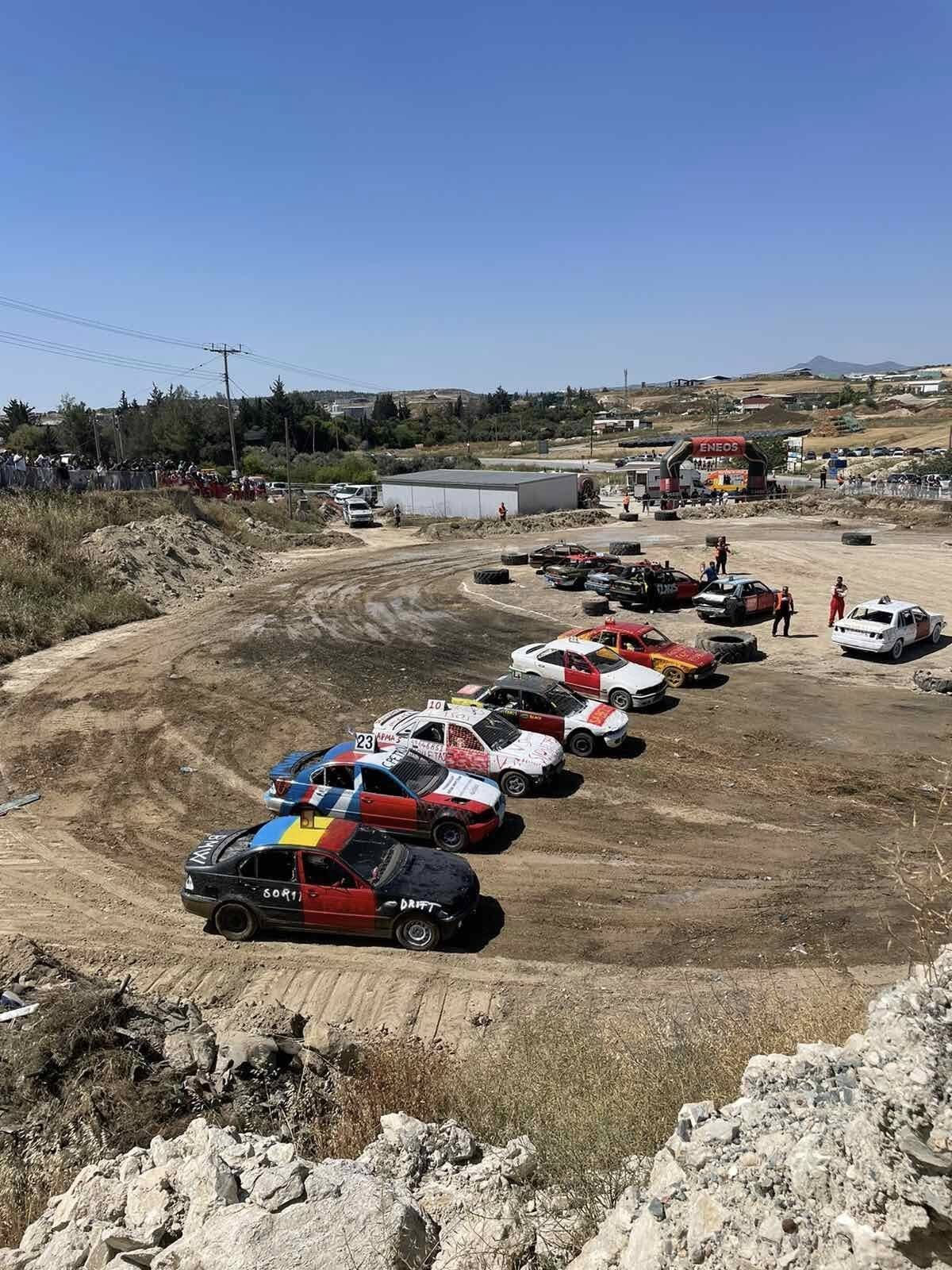 Βαμμένα αγωνιστικά αυτοκίνητα παραταγμένα σε καμπύλη χωμάτινης πίστας